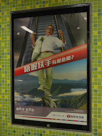 a hold the handrail MTR sign with a man perilously standing on a high rock