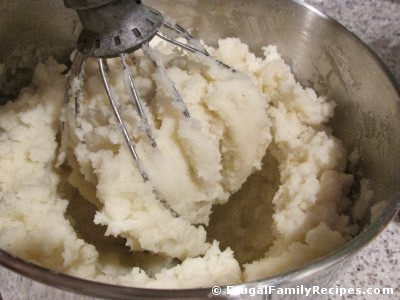 mashing potatoes in mixing bowl