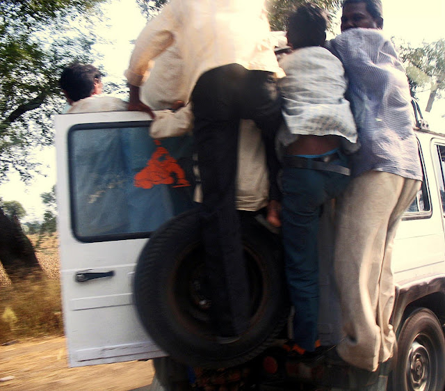 close-up of people spilling out of moving taxi