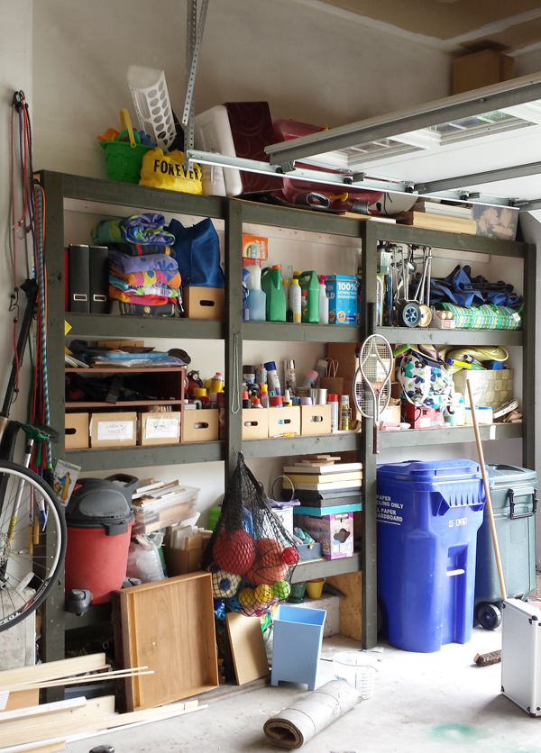 a built-in of shelves in the garage with lots of supplies