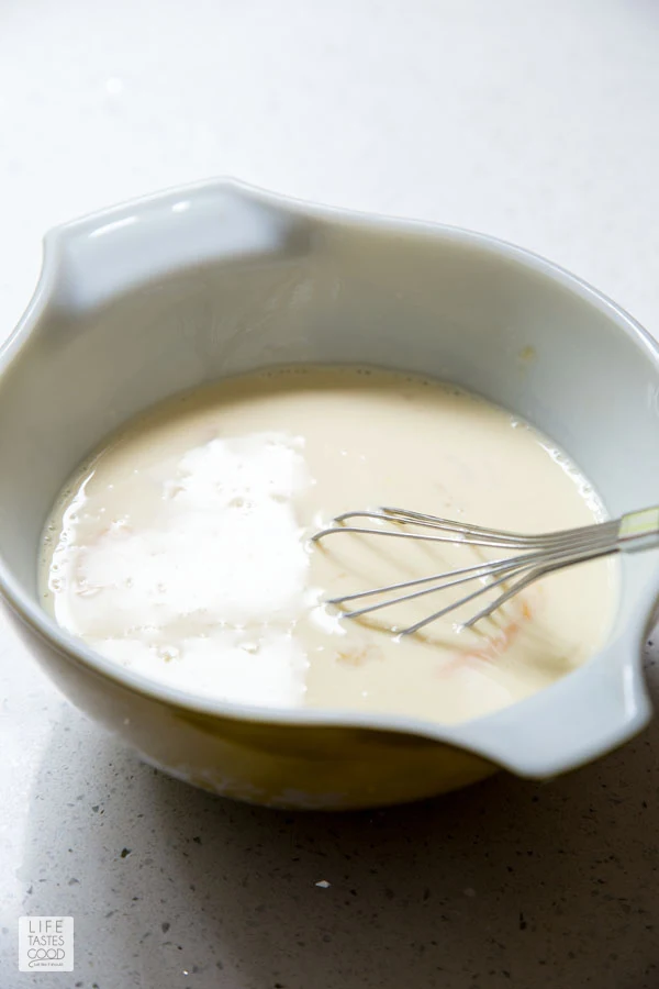 Whisking the custard mixture in a mixing bowl for Alton Brown French Toast