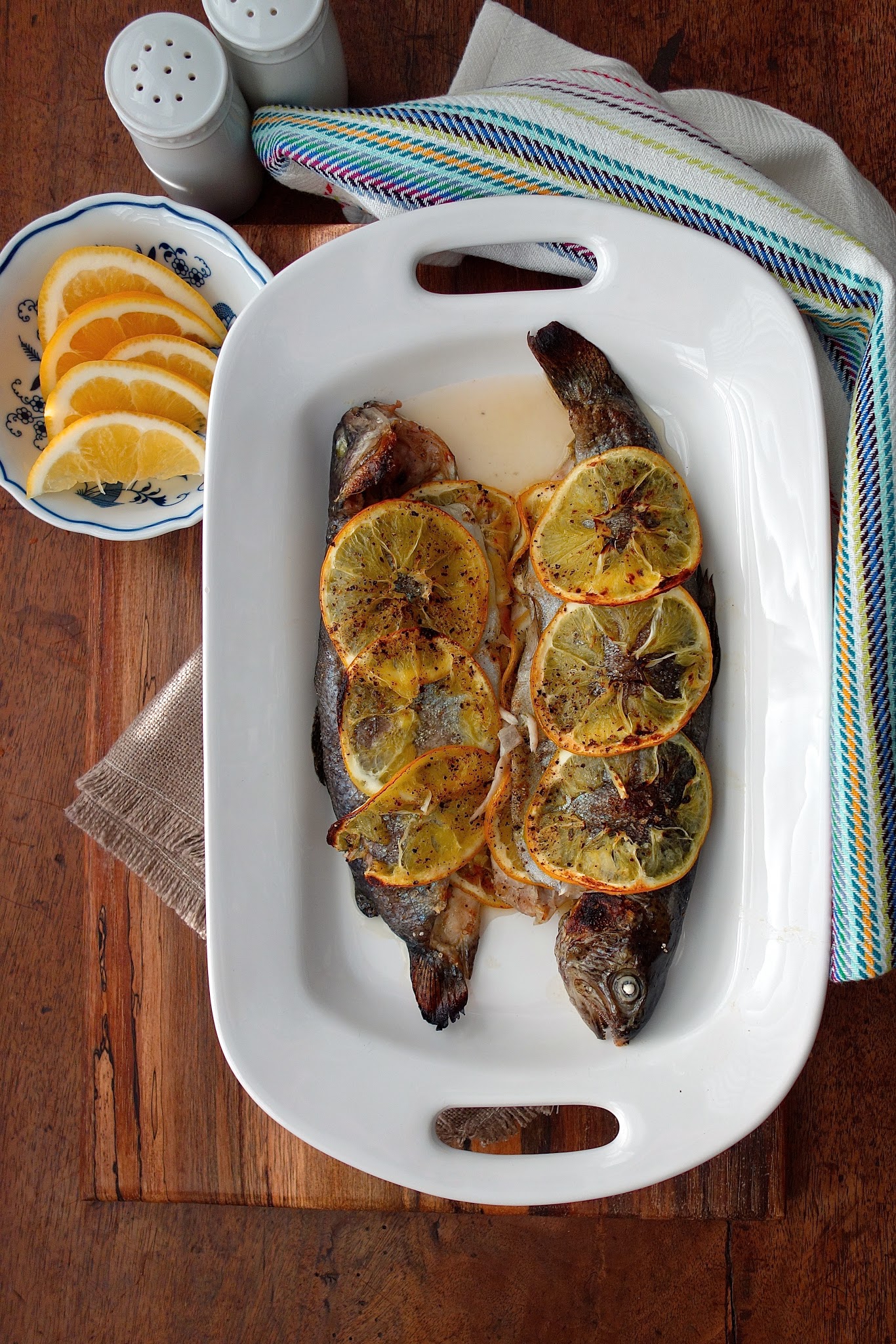 Baked Whole Rainbow Trout with Shallots, Herbs, and Jalapeño on a white platter.