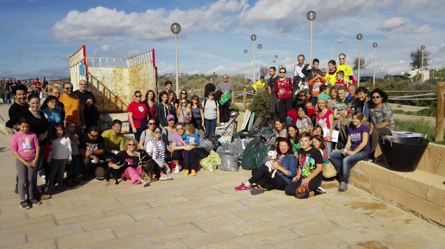 Grupo de voluntarios posando junto a la basura recogida y el camión de EMAYA.