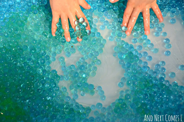 Child's hands in a water bead sensory bin
