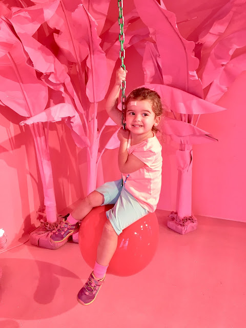 A toddler girl sitting on a cherry wrecking ball