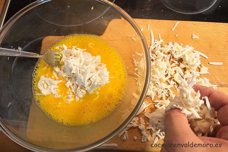 Mezclando la yuca y el queso rallados con el huevo batido