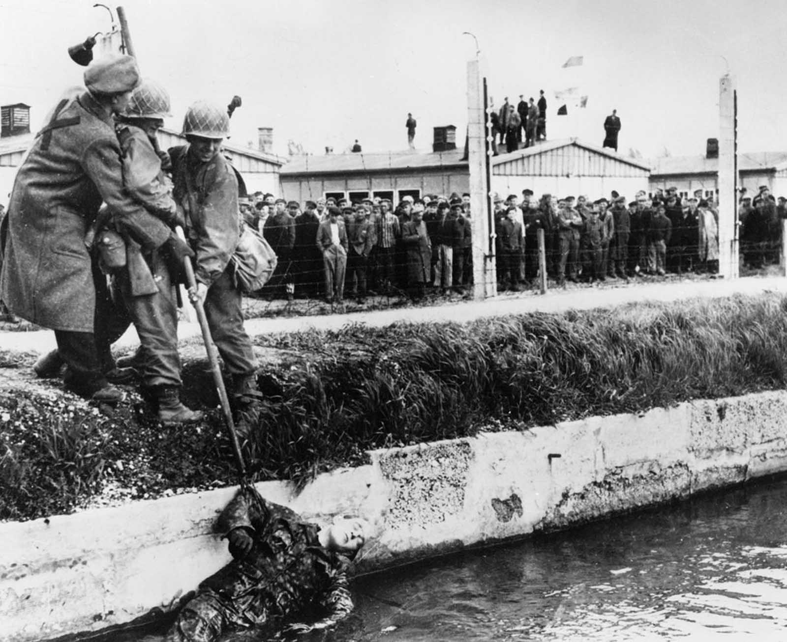 When American troops liberated prisoners in the Dachau concentration camp, Germany, in 1945, many German SS guards were killed by the prisoners who then threw their bodies into the moat surrounding the camp.