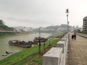 couple walking together on a wall bordering the Gui River (桂江) in Wuzhou (梧州)