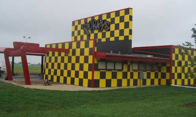 Yellow and dark brown checkered drive in restaurant with Porky's light bulb sign on the side