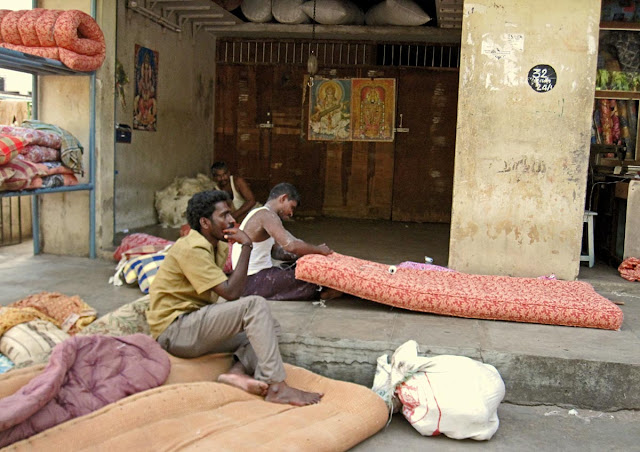 workers packing a mattress with cotton