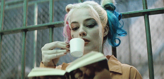 Harley Quin sipping tea and reading in prison