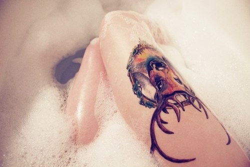 Precioso tatuaje de cabeza de venado en el muslo de una chica que se esta bañando