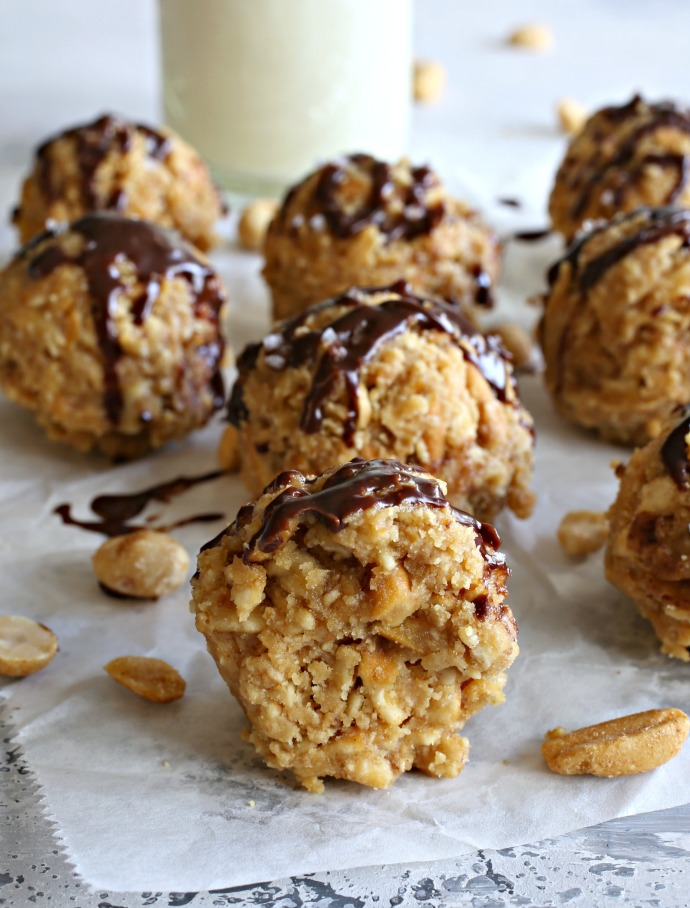 Peanut butter balls filled with pretzels and peanuts, topped with melted chocolate.