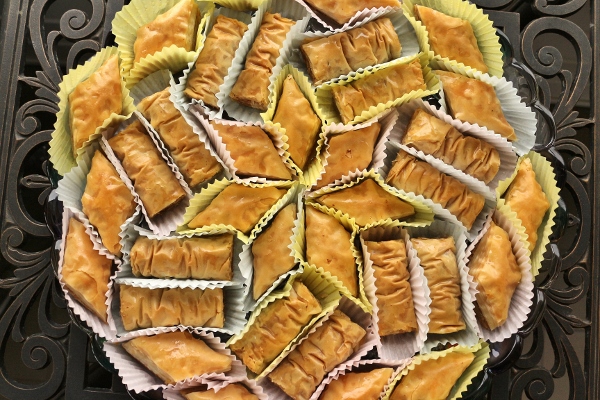 Tray of assorted baklava and bourma baklava pastries served in paper cupcake liners