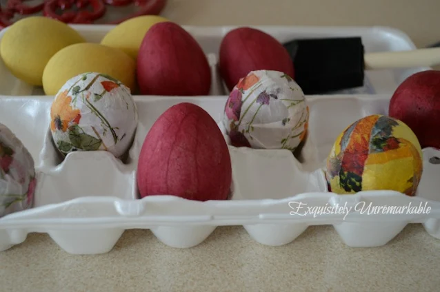 Decoupaged and painted eggs in a carton