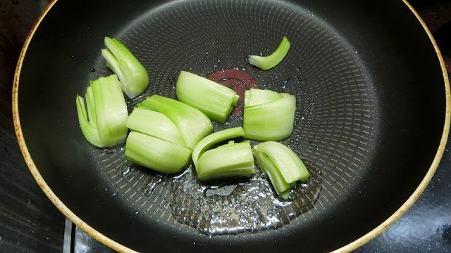 フライパンにオリーブオイル、4つ割りに切った茎を中火で炒める