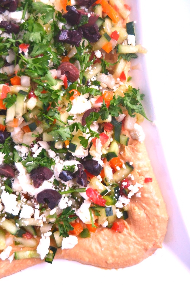 This Mediterranean layered dip features hummus, feta, olives and is loaded with diced vegetables. A quick and flavorful appetizer that no one will know only took you 10 minutes to make! www.nutritionistreviews.com