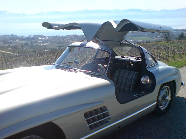 Silberner Mercedes Benz 300SL mit offenen Gullwing Türen, Sonne, Weinberge