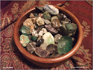 Witch Whats cleansed stones in a wood bowl.