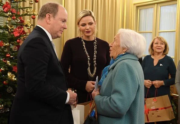 Princess Charlene wore a wool cashmere brown coat and brown long sleeve wool midi dress by Louis Vuitton