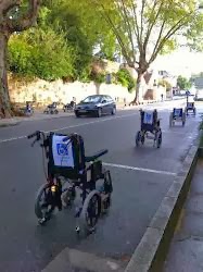 Line of empty wheelchairs parked in standard street side parking spaces in protest about handicapped parking
