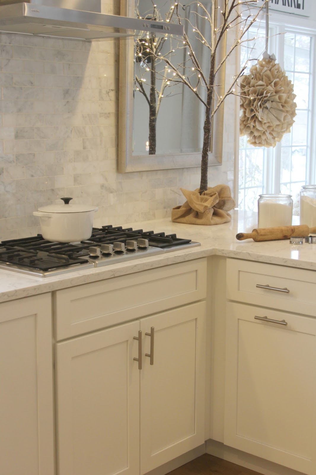 White kitchen decorated for Christmas with small tree and paper wreath - Hello Lovely Studio