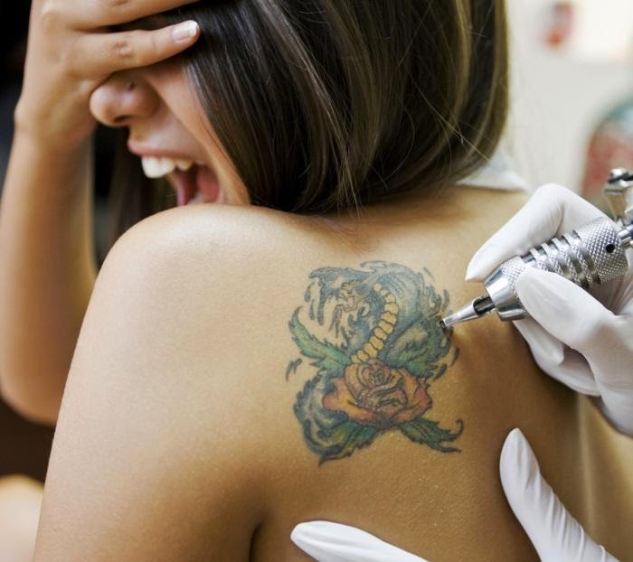 Chica gritando de dolor mientras la tatuan