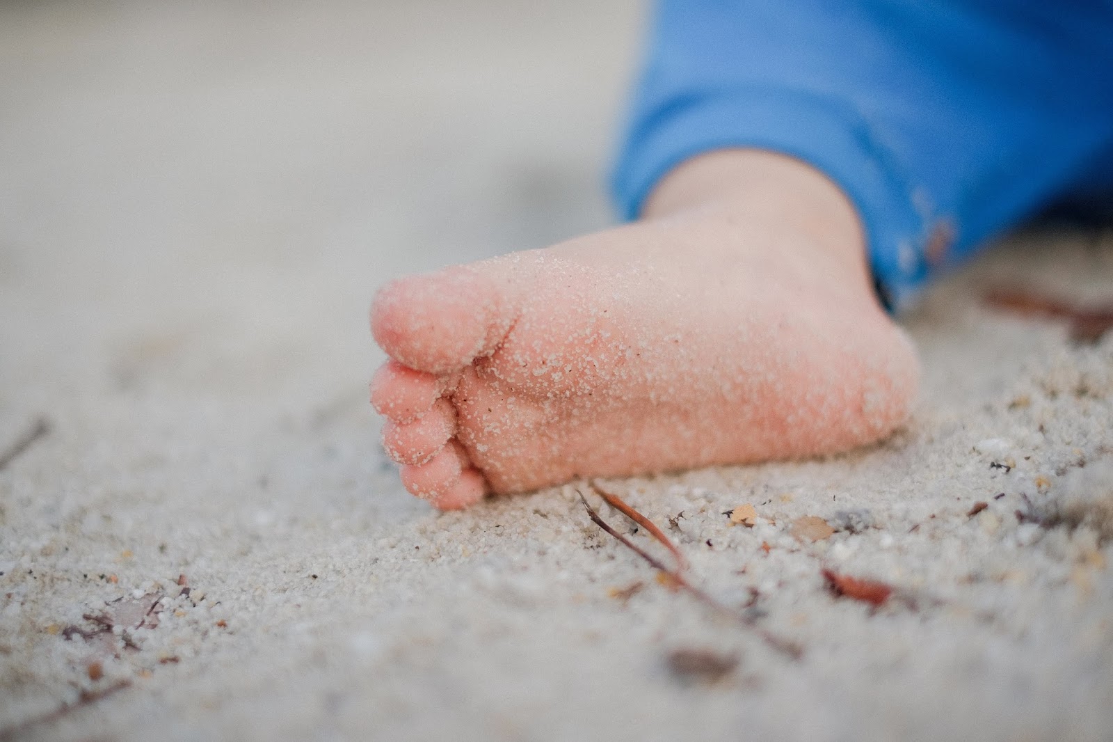 Foot of a baby playing on a beach