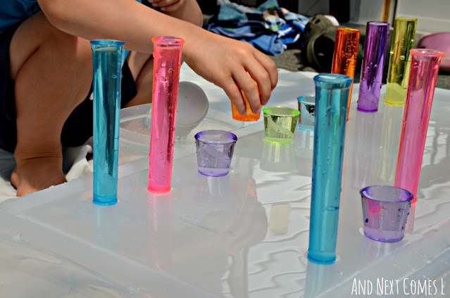 Child playing with colorful cups filled with water