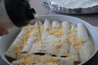 Egg mixture being poured over the rolled up tortillas topped with shredded cheese.
