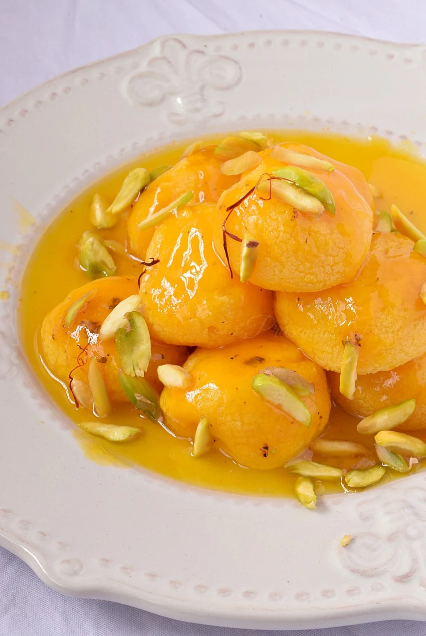 White plate with Cottage Cheese dumplings in mango puree