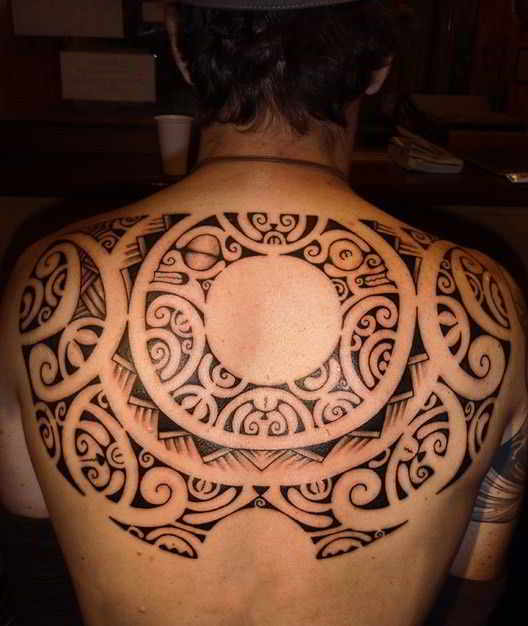 un tatuaje maori en la espalda de un hombre