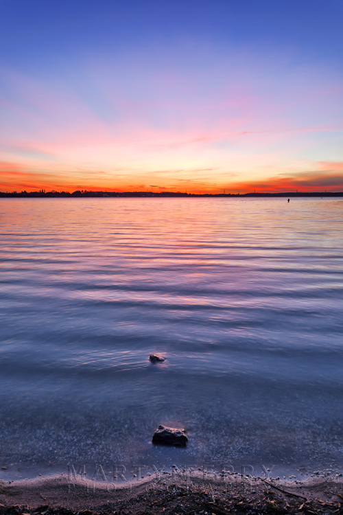 Grafham Water reservoir at sunset with glowing colours Ripples on the reservoir at Grafham Water under a sunset sky