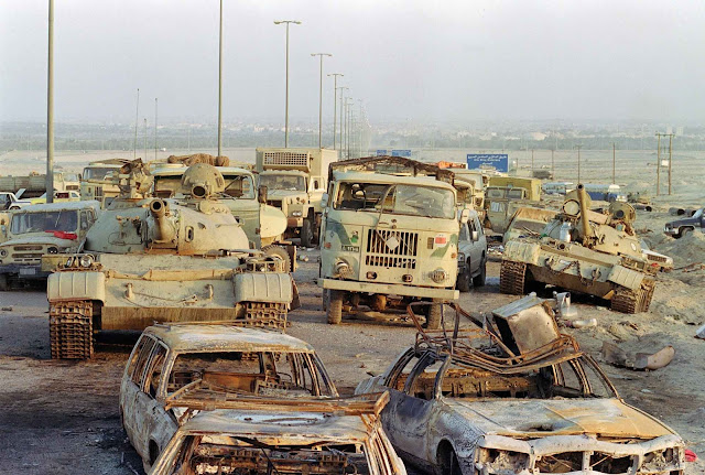 A long line of vehicles, including destroyed Iraqi Army Russian-made T-62 tanks and trucks stand abandoned by fleeing Iraqi troops.
