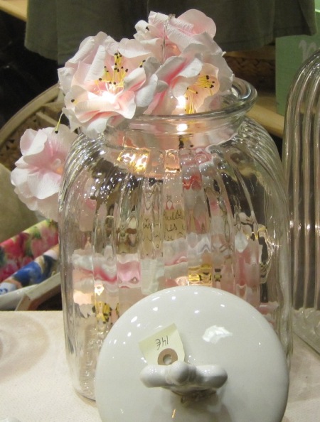 Tarro de cristal con tapa cerámica blanca. Guirnalda luz flores rosa