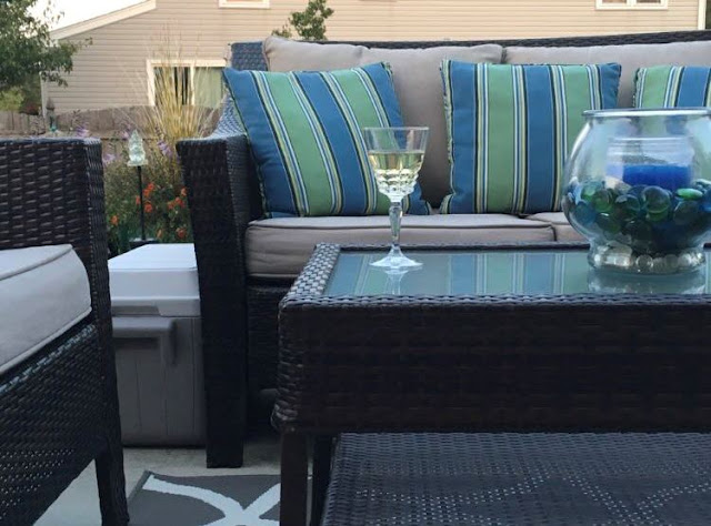 Backyard/outdoor area decorated with colorful pillows, flowers, décor, and crafts appropriate for summer season.