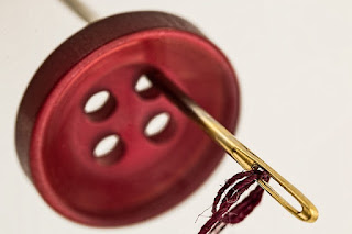 image of button, needle and thread