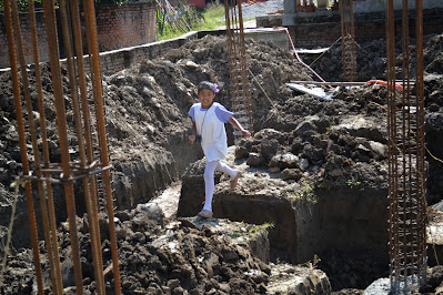 Nepali girl running through a house under construction