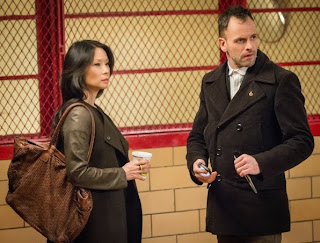 Jonny Lee Miller and Lucy Liu as Sherlock Holmes and Joan Watson in CBS Elementary Season 2 Episode 17 Ears To You