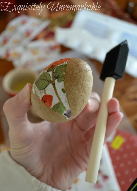 Hand holding an egg with napkin on it