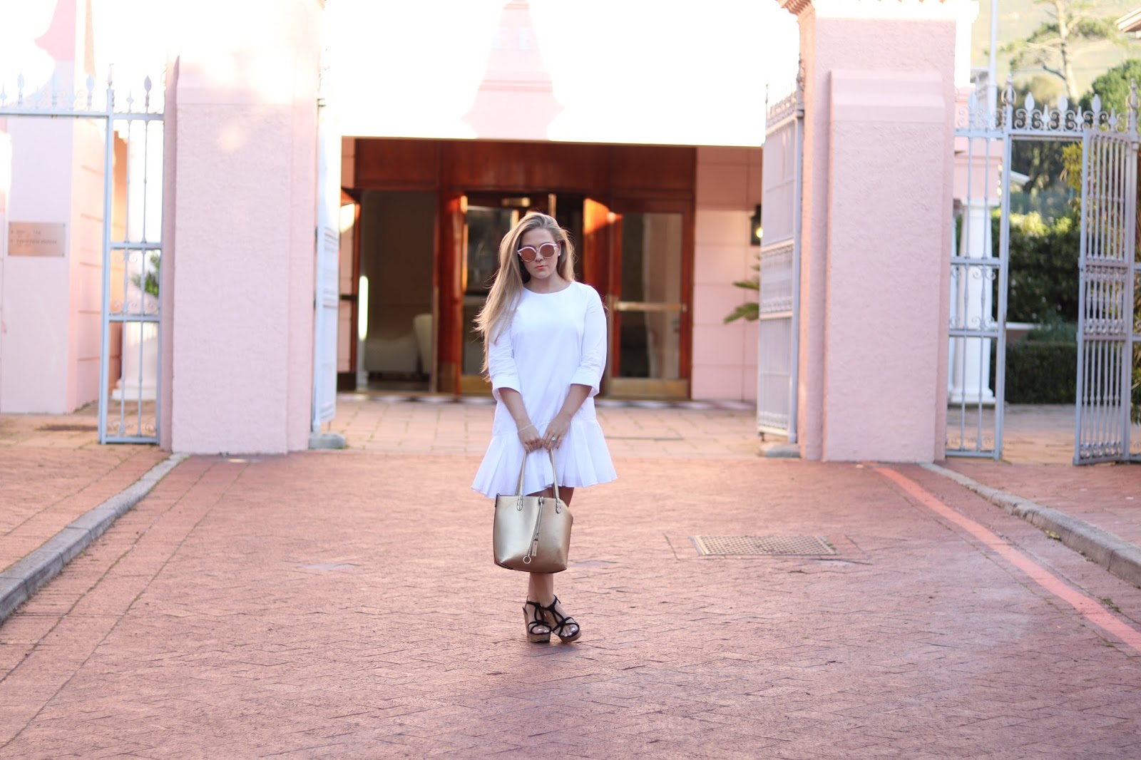 Katie Heath wearing white dress and wedges at the Belmond Mount Nelson Hotel