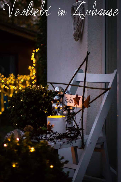 Haustüdeko im Winter zu Weihnachten mit selbst gemachten Stern aus Ästern und schönen Lichter Bokeh