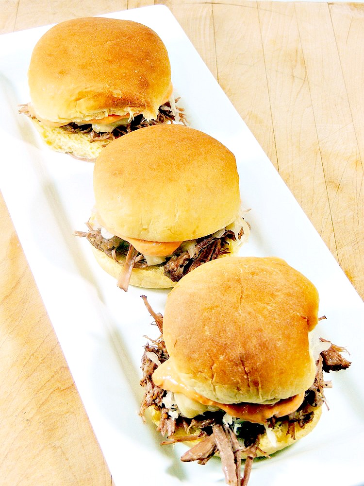 Make this Reuben Sliders recipe for your next Super Bowl or St Patrick's Day party. They are cute, tasty, and sure to please your guests! BONUS is that you make the corned beef in your slow cooker for set it and forget it preparation. For a keto, version try making them into lettuce wraps or use fat head dough buns! #slowcooker #beef #cornedbeef #keto #stpatricksday #superbowl #gameday #recipe | bobbiskozykitchen.com