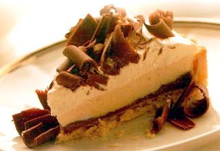 Classic recipe for the three layered chocolate pie (Mississippi mud pie) served as a wedge and topped with chocolate curls.