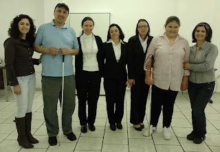 Começando pelo lado direito de quem olha: Chica, Airton, Marilene, Cida, Isolete, Kelli e Maria Izabel. Todos em pé, posando para foto. (risos)