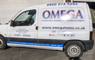 Omega van side of livery vinyl graphics and printed logo. The telephone number 0800 072 6262 is cut vinyl letters on top of the van, underneath is the blue gradient logo, with a white then a red border, under the omega logo is windows doors and conservatories in vinyl letters. Under that is the website www.omegahome.co.uk.