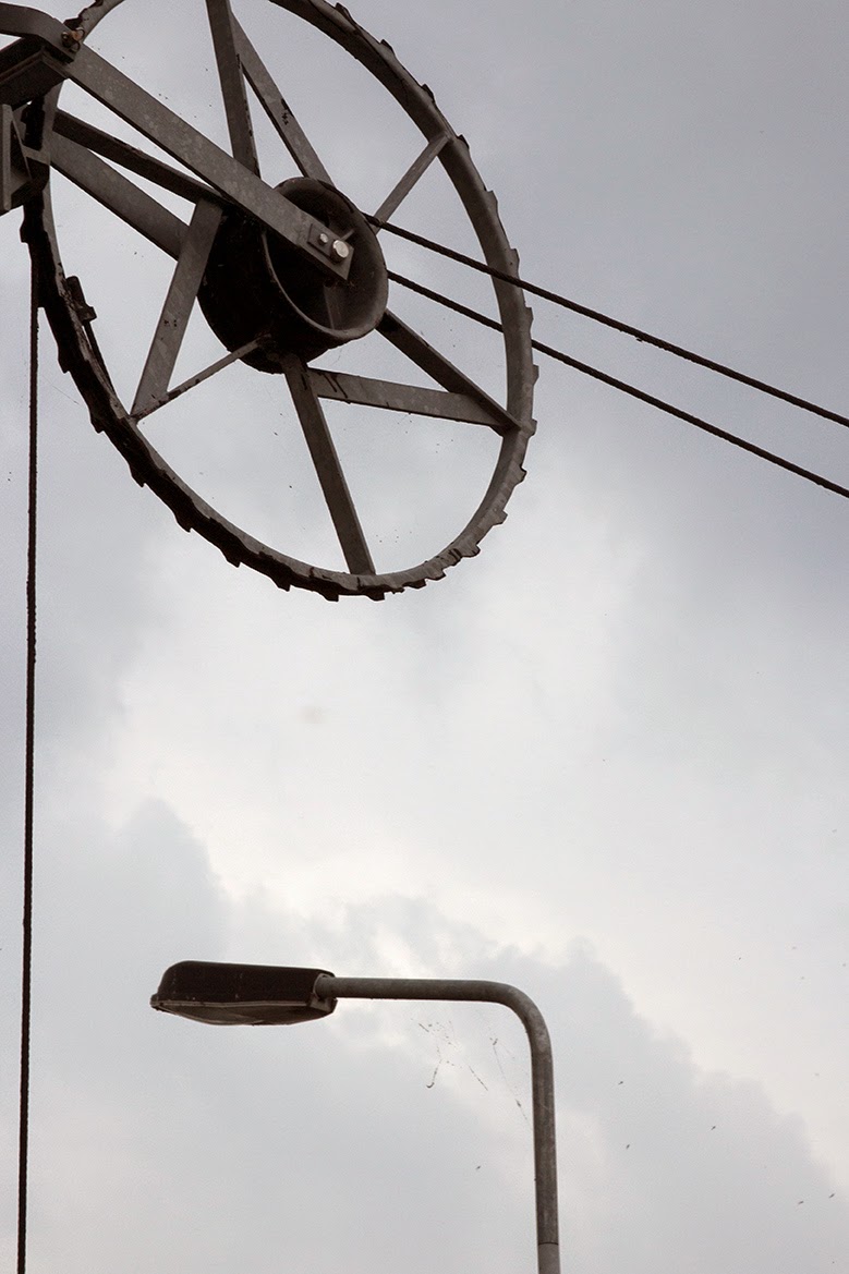 wheel and lamppost against grey sky
