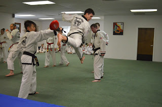 A martial arts black belt doing a jump back kick while learning martial arts