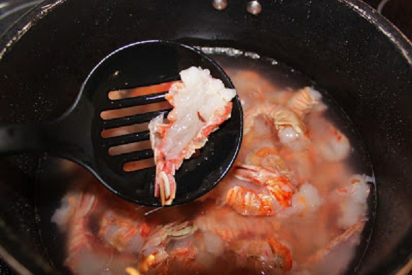 how to clean and cook rock shrimp these are on a white plate and butterflied with herb sauce