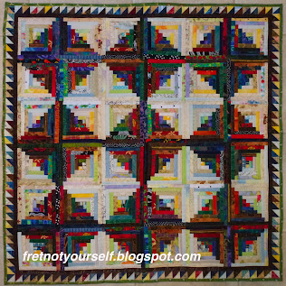 Log Cabin quilt with half-inch logs and a sawtooth border.